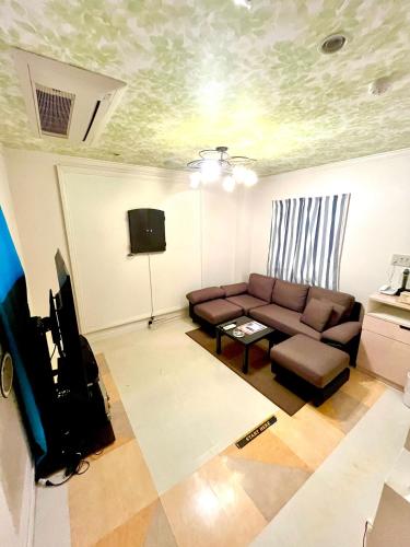 a living room with a couch and a tv at ホテルアンの家 in Ikaho