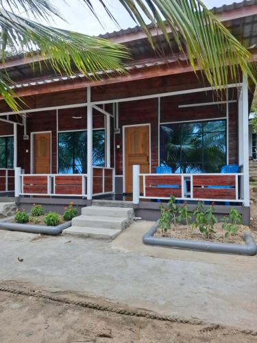 a house with a palm tree in front of it at Ella's Place Salang Tioman in Tioman Island