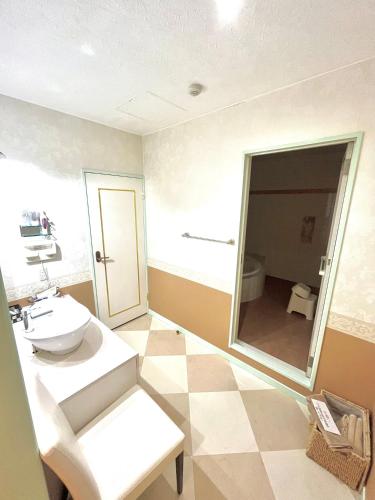 a bathroom with a sink and a mirror at ホテルアンの家 in Ikaho