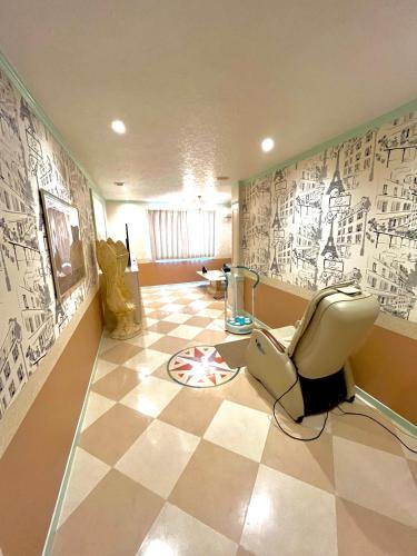a room with a chair on a checkered floor at ホテルアンの家 in Ikaho