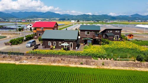 an aerial view of a house with a field of flowers at Country Cottage Wakiaiai in Nakafurano