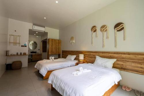 a bedroom with two beds with white sheets at E-Fun Dive Resort in Dauin