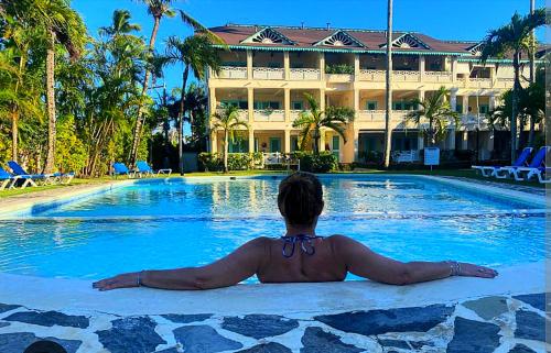 a person sitting on a surfboard in the swimming pool at A La Dolce Vita Beachfront Hotels, Las Terrenas, Samana in Las Terrenas
