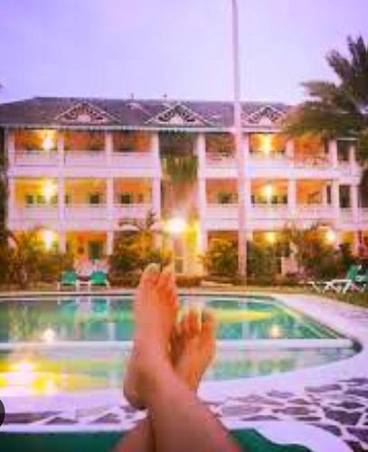 a person with their feet up next to a swimming pool at A La Dolce Vita Beachfront Hotels, Las Terrenas, Samana in Las Terrenas