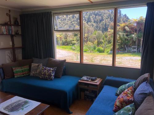 a living room with a blue couch and a large window at Wahapo Lodge in The Forks