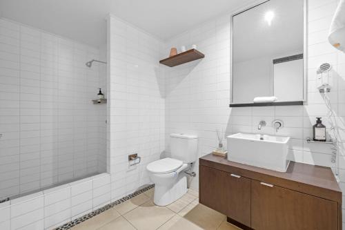 Un baño con inodoro, lavabo y ducha. en Paradiso Beachfront Apartment, en Kingscliff