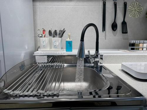 a kitchen sink with water coming out of it at Brownie stay daegu banwoldang 3 rooms in Daegu