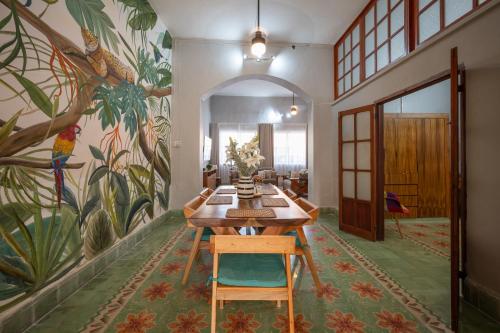a dining room with a table and a mural at La Casa del Jaguar in Mérida