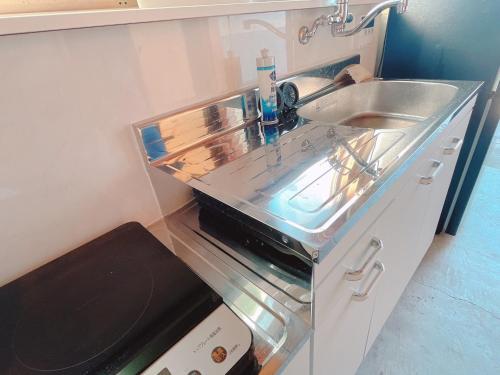 a small kitchen with a sink and a microwave at 淡路屋-Awajiya vacation home-ドッグラン付き別荘 BBQ PET OK in Awaji