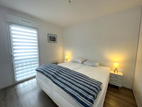- une chambre avec un lit et une fenêtre avec deux lampes dans l'établissement Appartement 4 pers - Village de Vieux-Boucau avec parking - FR-1-379-179, à Vieux-Boucau-les-Bains