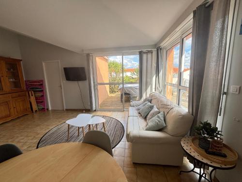 un salon avec un canapé et une table dans l'établissement Maison fonctionnelle avec jardin et parking privé aux Sables-d'Olonne - FR-1-197-619, à Les Sables-dʼOlonne