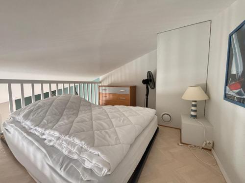 une chambre avec un lit blanc et une lampe dans l'établissement Maison fonctionnelle avec jardin et parking privé aux Sables-d'Olonne - FR-1-197-619, à Les Sables-dʼOlonne