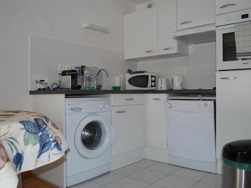 une cuisine avec un lave-linge et un micro-ondes dans l'établissement Appartement moderne à 2 min de la plage, vue mer, animaux admis - FR-1-482-153, à Fort-Mahon-Plage
