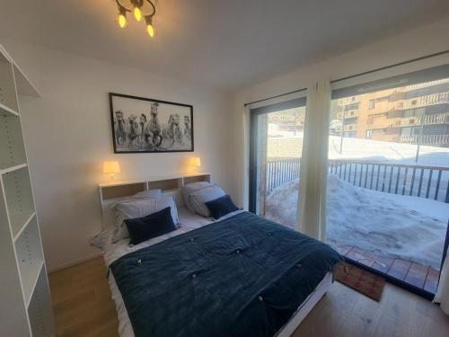 une chambre avec un grand lit et une grande fenêtre dans l'établissement Appartement Montagne 3 pièces avec parking et wifi - FR-1-266-247, à Montgenèvre
