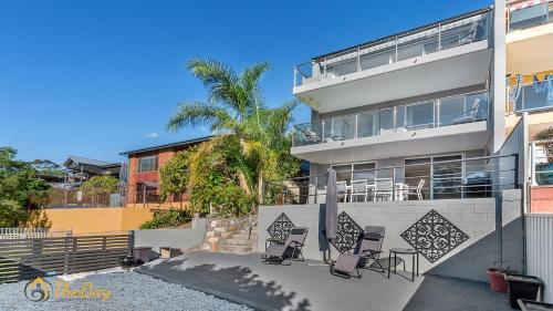 a apartment building with chairs in front of it at Water Views on Wallawa in Nelson Bay