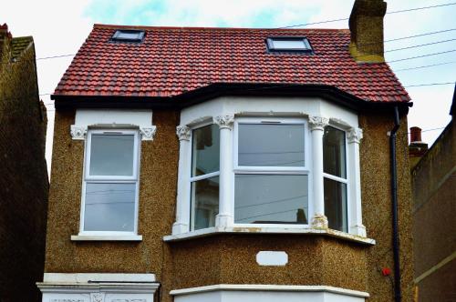 a building with a red roof and two windows at Thornton Heath in Thornton Heath