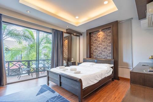 a bedroom with a bed and a large window at Thai Me22 3B near Hollywood in Pattaya Central