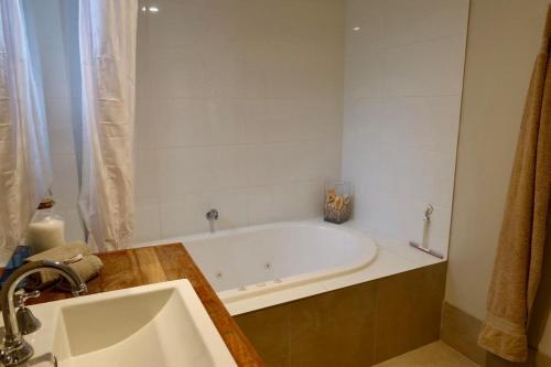 a bathroom with a bath tub and a sink at Unique Australian Shed Style House in Dunsborough