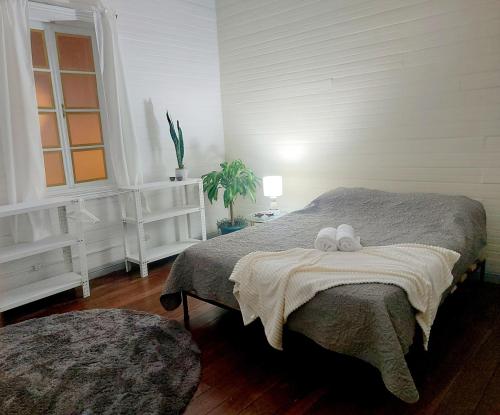 a bedroom with a bed with two stuffed animals on it at The Nomad Hostel in Alajuela City