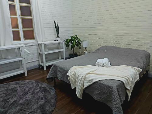 a bedroom with a bed with two towels on it at The Nomad Hostel in Alajuela City