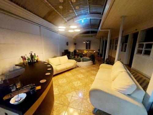 a living room with two white couches and a table at The Nomad Hostel in Alajuela City