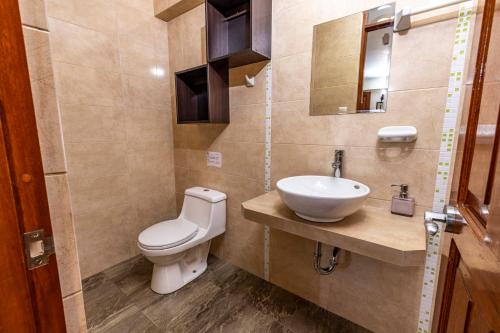 a bathroom with a toilet and a sink at Hotel Sky Mirador in Cusco