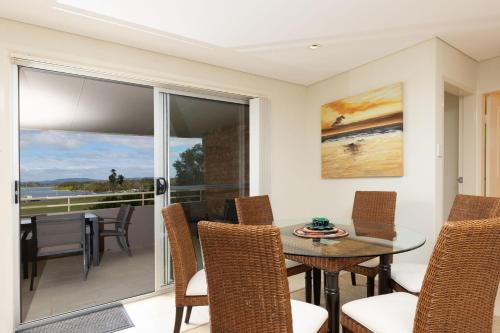 a dining room with a table and chairs at Tuncurry Tides in Tuncurry