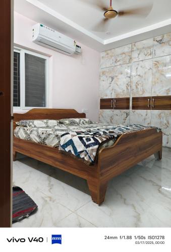 a bedroom with a wooden bed in a room at AJ srinivasa HOMESTAY in Tirupati