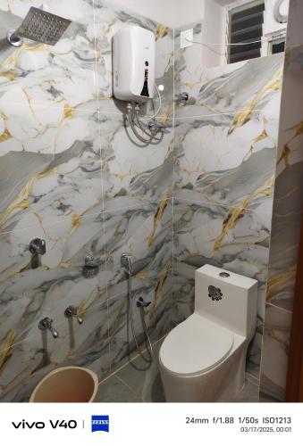 a bathroom with a toilet and a wall at AJ srinivasa HOMESTAY in Tirupati