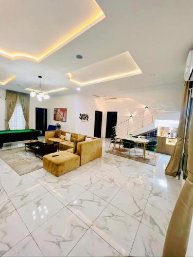 a large living room with couches and a pool table at Home away from Home in Lekki
