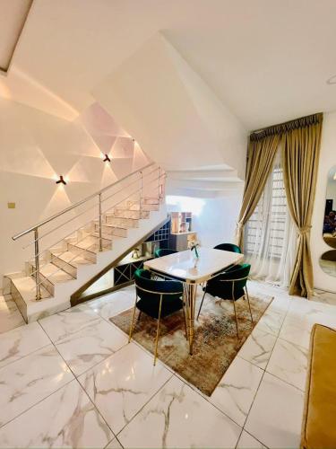 a living room with a table and a staircase at Home away from Home in Lekki