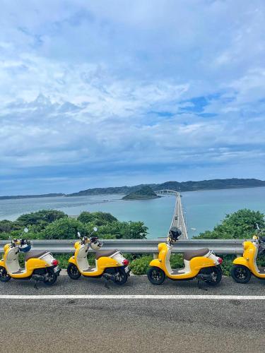 a row of scooters parked on the side of a road at ｹﾞｽﾄﾊｳｽ ﾊﾞｲｸﾔﾉﾆｶｲ in Hagi