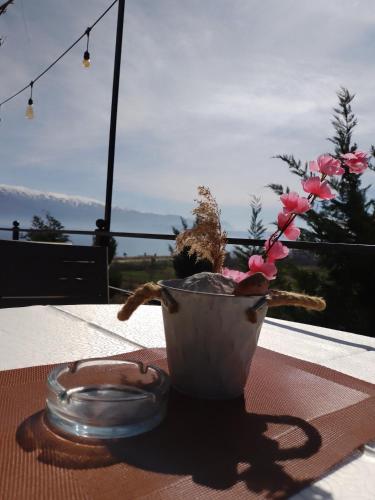 a vase with flowers in it sitting on a table at Hotel Villa Stone Dream Bar Restaurant in Pogradec