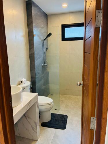 a bathroom with a toilet and a glass shower at GM Apartments 2 Bedrooms in Amphoe Koh Samui