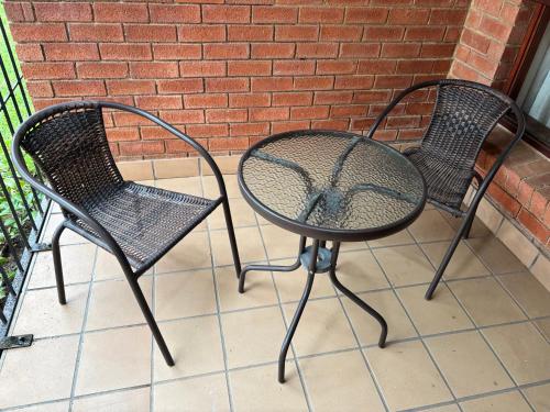 two black chairs sitting next to a brick wall at Savannah Lodge Apartments unit 81 in Roodepoort