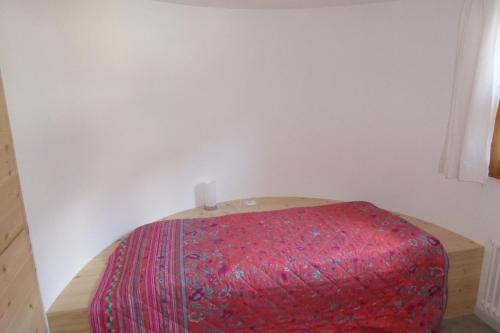a red ottoman in a corner of a room at Apartment for 1-4 people Chasa Plazzöl in Müstair