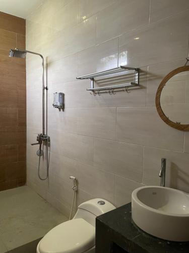 a bathroom with a toilet and a sink at Tantra Hotel in Krui