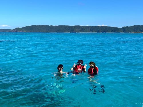 two people in the water in the ocean at 民宿ひじゃぐゎー in Zamami