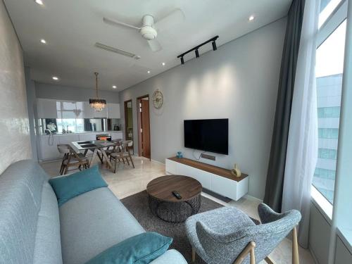a living room with a blue couch and a tv at Sky Suites By JK in Kuala Lumpur