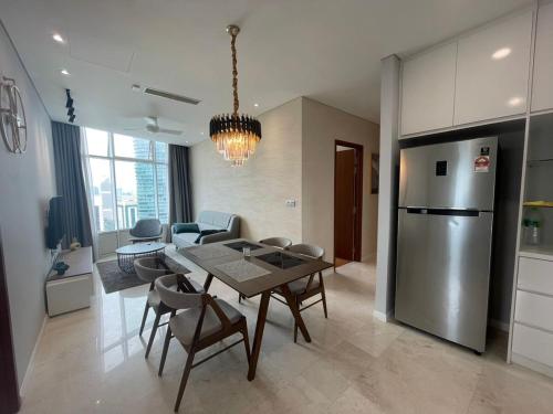a kitchen and dining room with a table and a refrigerator at Sky Suites By JK in Kuala Lumpur