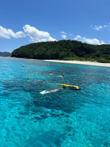 a group of people swimming in the ocean at 民宿ひじゃぐゎー in Zamami