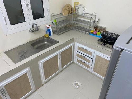 a kitchen with a sink and a refrigerator at Luban Camping House in Bidiyah