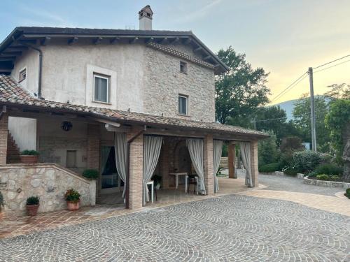 a large stone house with a patio in front of it at Agriturismo Il Casale Dei Gelsi in Monte San Biagio