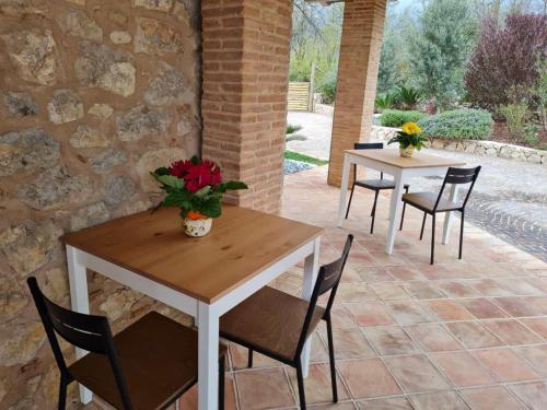 two tables and chairs with flowers on a patio at Agriturismo Il Casale Dei Gelsi in Monte San Biagio