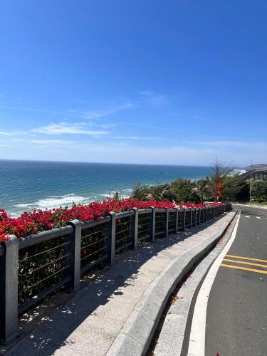 a road with flowers on the side of the ocean at Apec Mandala Wyndham Mui Ne by HK S0624 in Ấp Thiẹn Ái