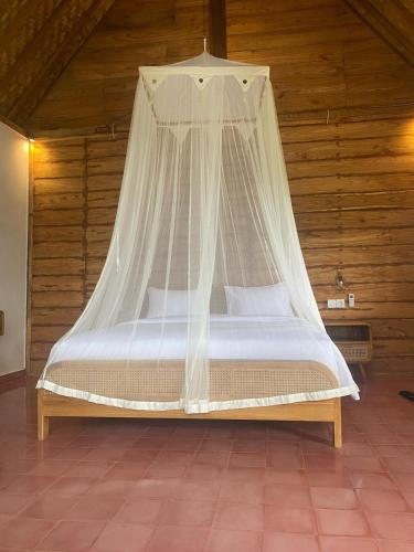 a bed with a mosquito net in a room at Green vanilla kabin in Silebeng