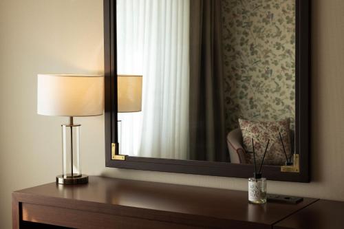 a room with a mirror and a lamp on a table at KensingtonHotel Seorak in Sokcho