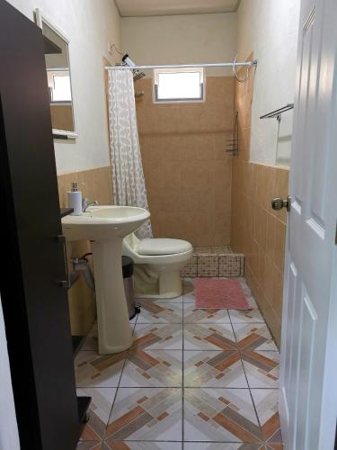 a bathroom with a toilet and a sink at Grutas el Encanto - Casa de la Colina - Ruta a Petén in Rio Dulce