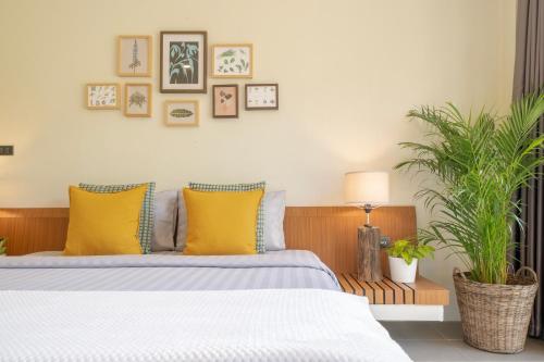 a bedroom with a bed with yellow pillows at Sirin Farm Chiang Rai in Ban San Ton Ko (1)