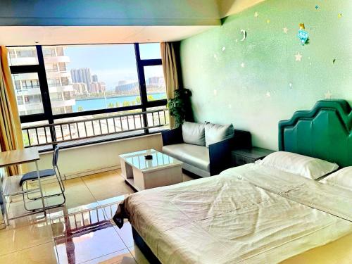 a bedroom with a bed and a couch and a window at JiuJiu Binhai Hotel in Huangdao